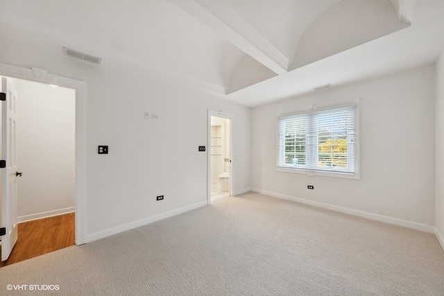 spare room featuring vaulted ceiling with beams and light colored carpet