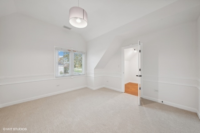 bonus room featuring vaulted ceiling and light carpet