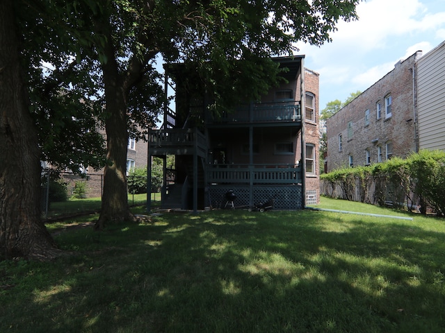 rear view of property with a wooden deck and a lawn