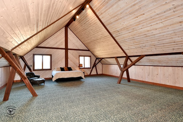 unfurnished bedroom featuring wooden ceiling, rail lighting, wooden walls, vaulted ceiling, and carpet floors