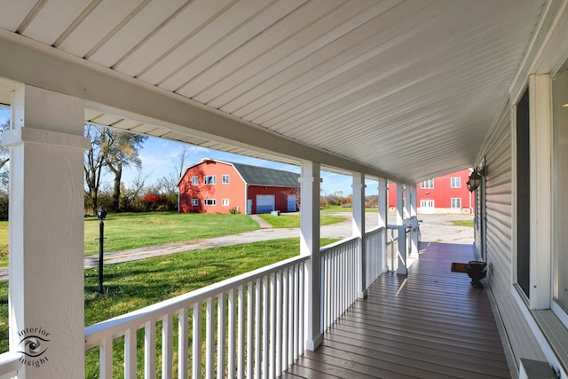 wooden deck featuring covered porch and a lawn