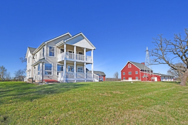 back of property with a yard and a balcony