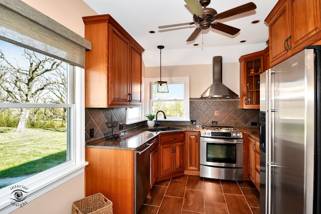 kitchen with wall chimney exhaust hood, sink, stainless steel appliances, and tasteful backsplash