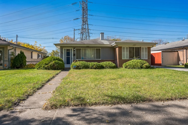 view of front facade featuring a storage unit and a front lawn