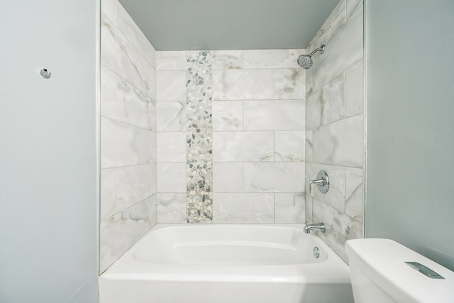 bathroom featuring toilet and tiled shower / bath combo