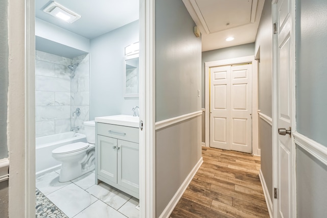 full bathroom with tiled shower / bath, vanity, hardwood / wood-style flooring, and toilet