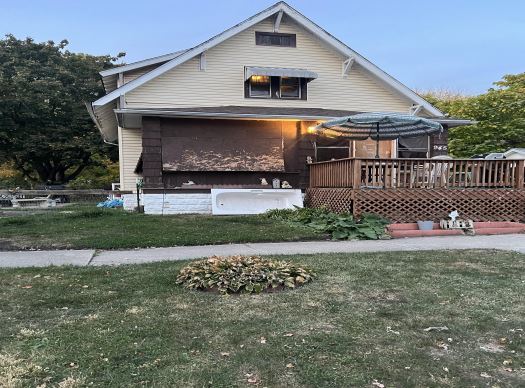 view of front of property featuring a deck and a front lawn