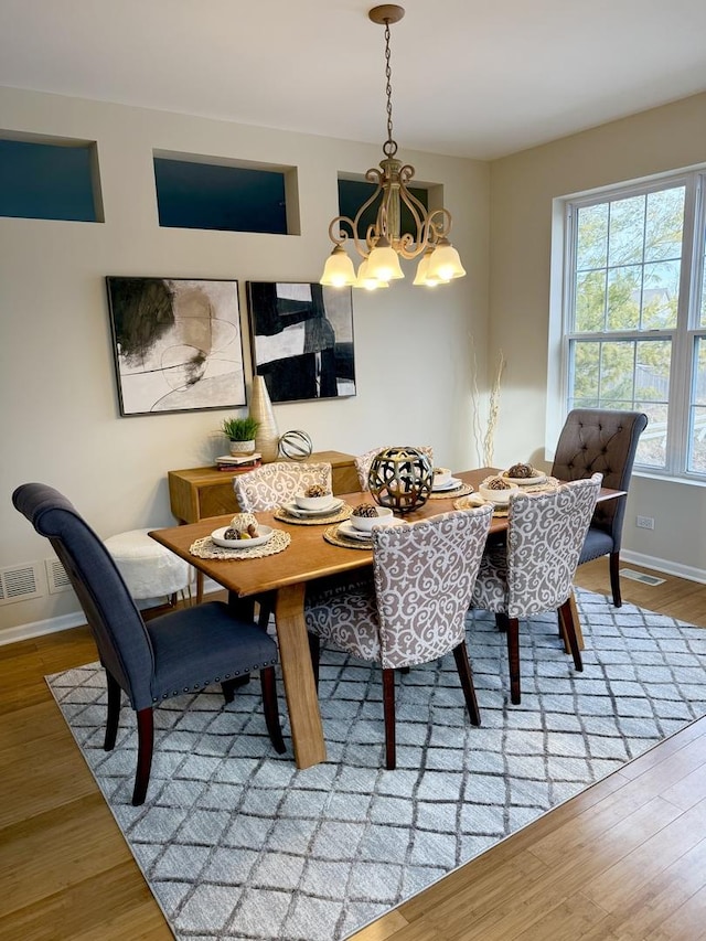 dining space with a notable chandelier and hardwood / wood-style flooring