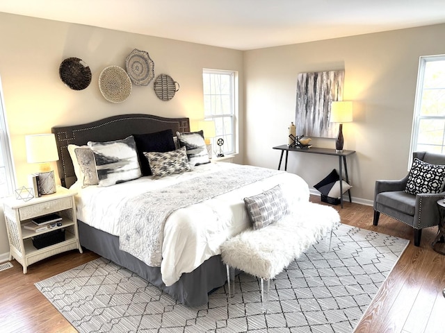 bedroom with multiple windows and wood-type flooring