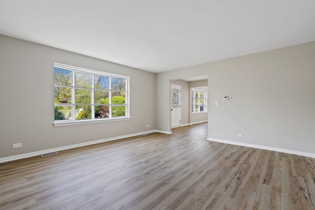 unfurnished room featuring a healthy amount of sunlight and light wood-type flooring