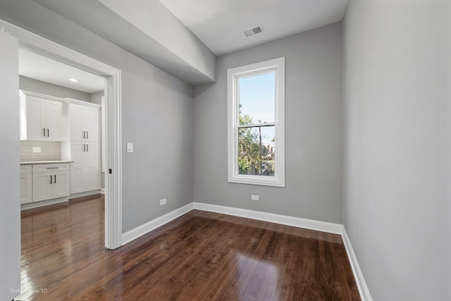 unfurnished room with dark hardwood / wood-style flooring