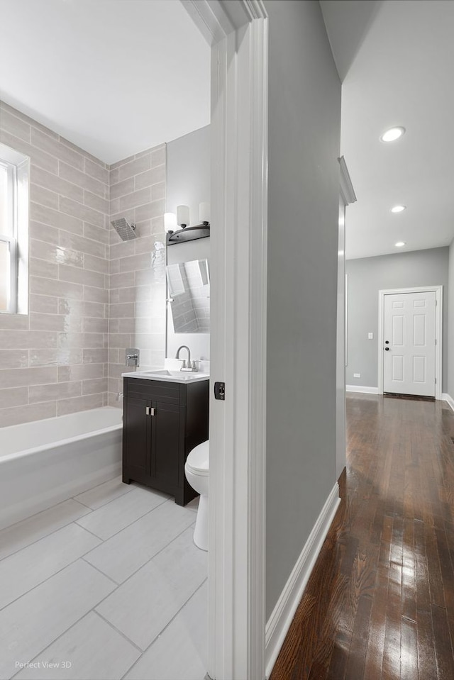 full bathroom with vanity, toilet, hardwood / wood-style floors, and shower / bathtub combination