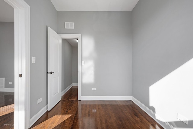 unfurnished room featuring dark wood-type flooring