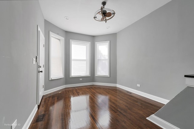 unfurnished room with ceiling fan and dark hardwood / wood-style flooring