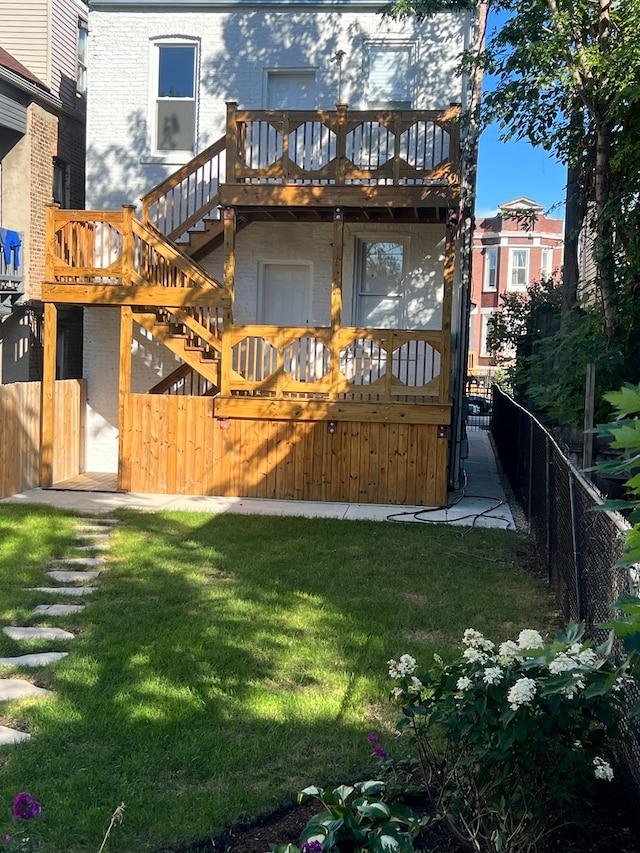 back of property featuring a yard and a wooden deck