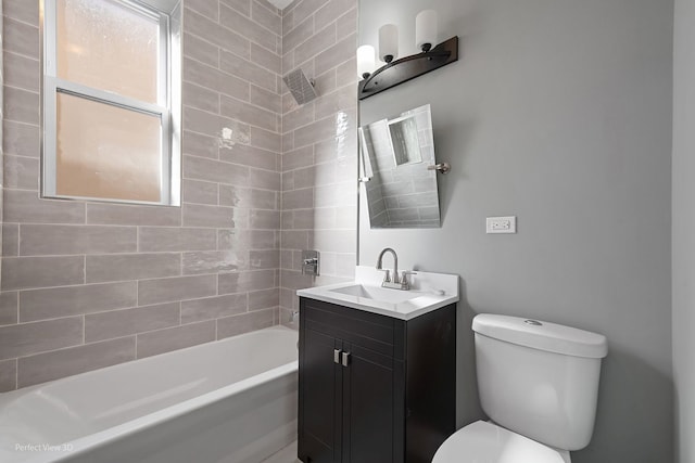 full bathroom featuring toilet, tiled shower / bath combo, and vanity