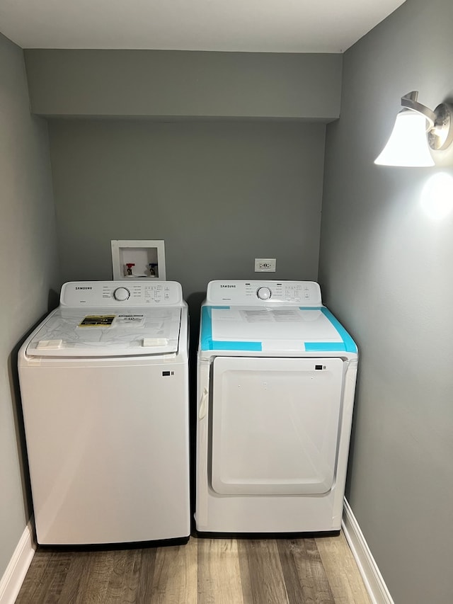 clothes washing area featuring hardwood / wood-style floors and washing machine and dryer