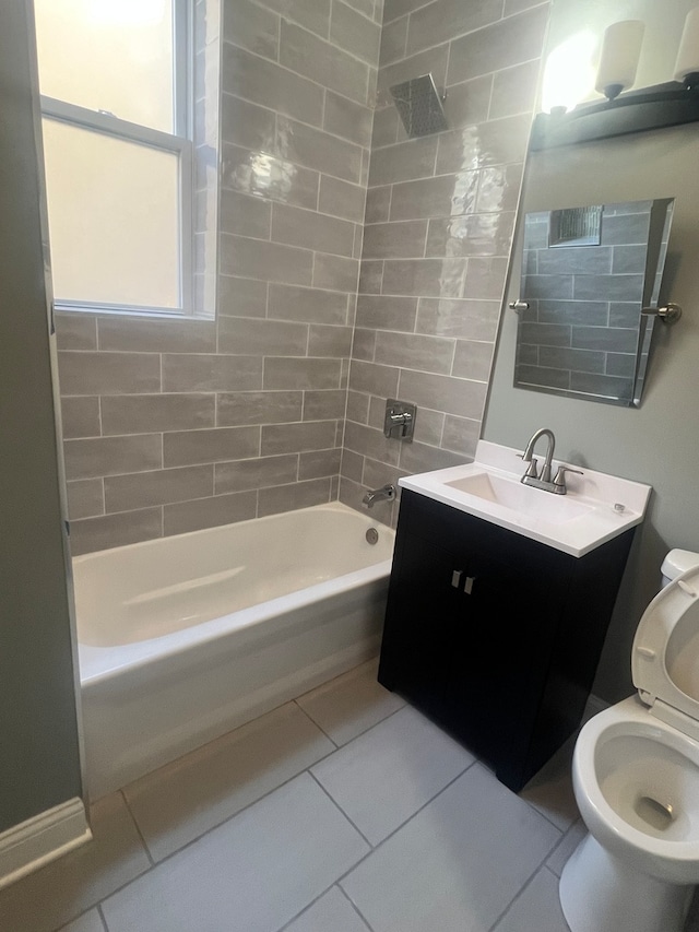 full bathroom featuring vanity, tiled shower / bath, toilet, and tile patterned floors