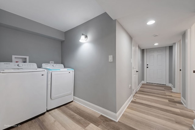 laundry area with light wood-type flooring and washing machine and clothes dryer