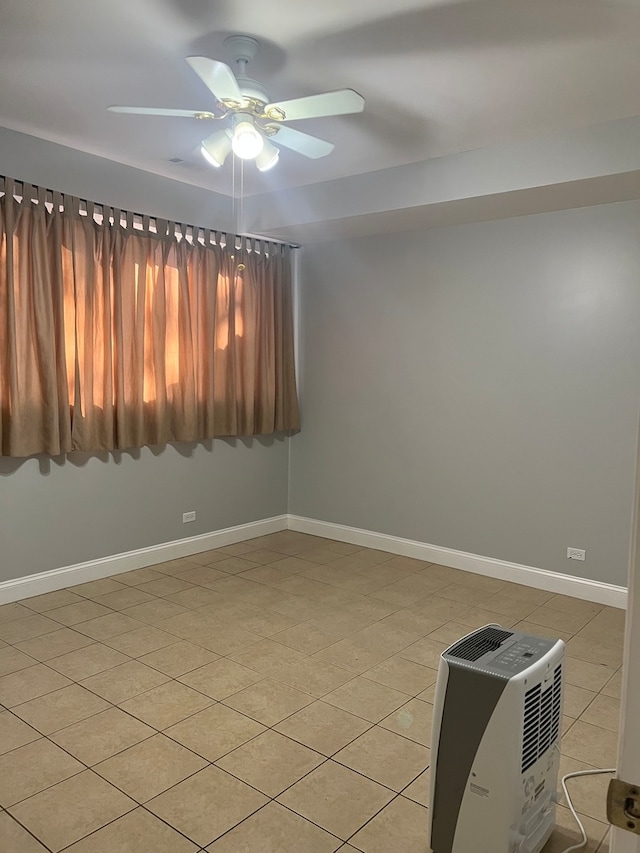 tiled empty room featuring ceiling fan