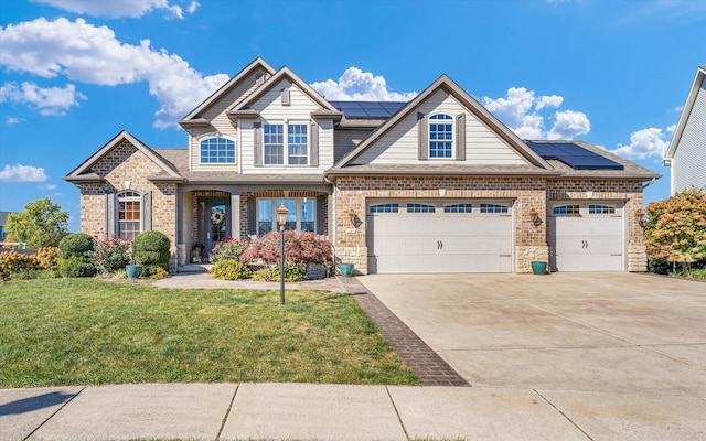 craftsman-style home with covered porch, a front yard, solar panels, and a garage