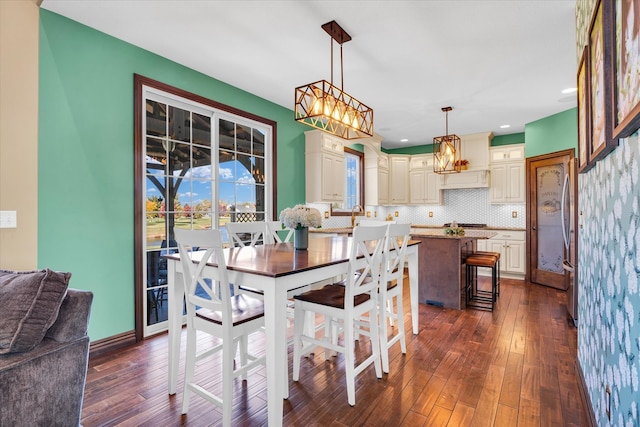 dining room with dark wood-type flooring and an inviting chandelier