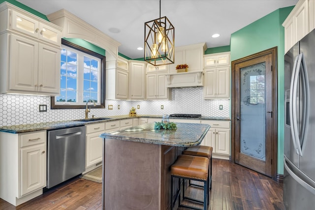 kitchen with tasteful backsplash, a center island, stainless steel appliances, dark stone counters, and dark wood-type flooring