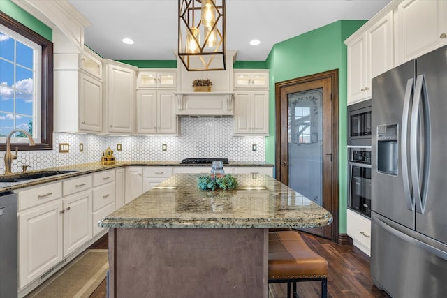 kitchen featuring white cabinets, stainless steel appliances, sink, and pendant lighting