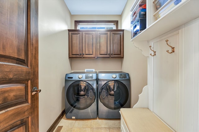 laundry area with washer and dryer, cabinets, and light tile patterned floors