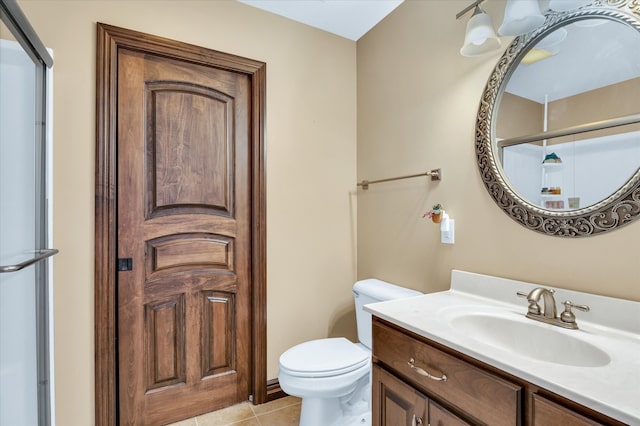 bathroom featuring vanity, toilet, walk in shower, and tile patterned flooring