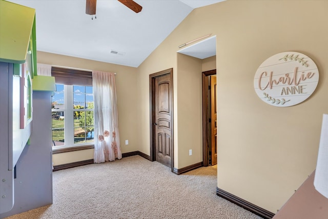 unfurnished bedroom with ceiling fan, light colored carpet, and vaulted ceiling