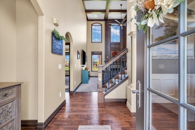 foyer with ceiling fan, coffered ceiling, a high ceiling, beam ceiling, and dark hardwood / wood-style floors