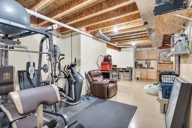 exercise room with brick wall and a workshop area