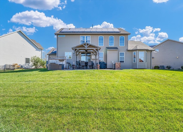 rear view of house with central AC, a patio, a gazebo, a lawn, and solar panels