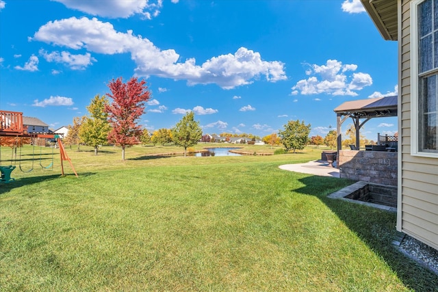 view of yard featuring a water view, a patio, and a playground