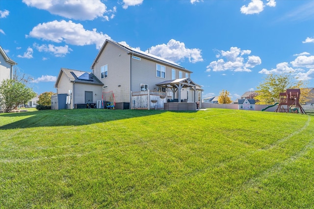 rear view of property with a gazebo, a lawn, and a playground