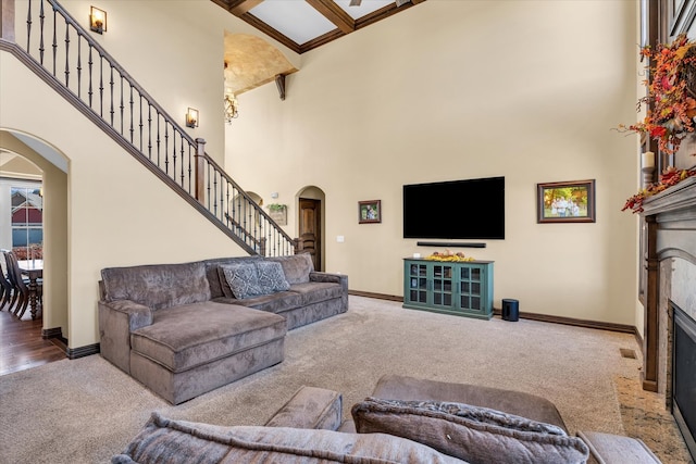 living room featuring beam ceiling, carpet flooring, and a high ceiling