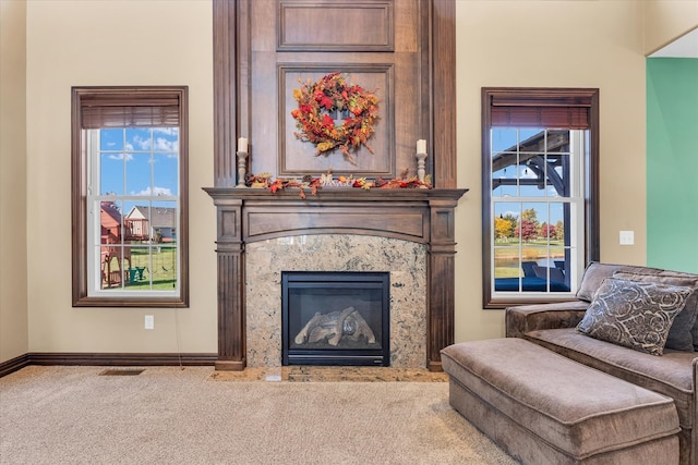 living room featuring a healthy amount of sunlight, carpet flooring, and a premium fireplace