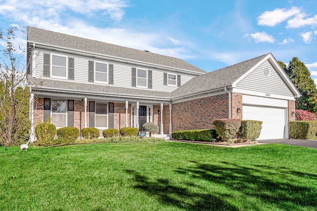 front facade featuring a porch, a front lawn, and a garage