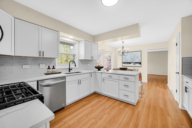 kitchen with dishwasher, white cabinets, kitchen peninsula, and light hardwood / wood-style flooring