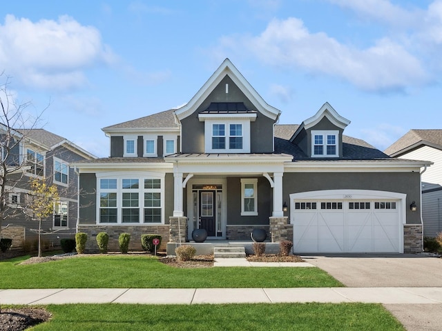 craftsman inspired home featuring covered porch, a garage, and a front yard