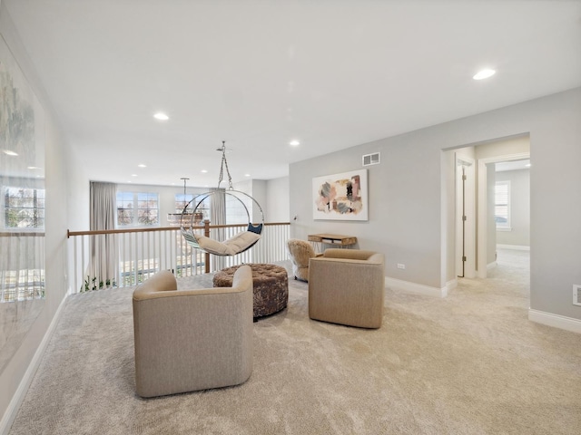 interior space with plenty of natural light, light colored carpet, and an inviting chandelier