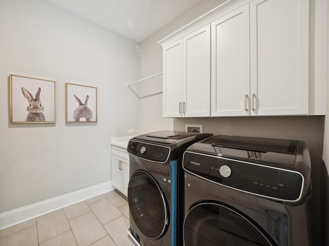 washroom featuring cabinets, separate washer and dryer, and light tile patterned flooring