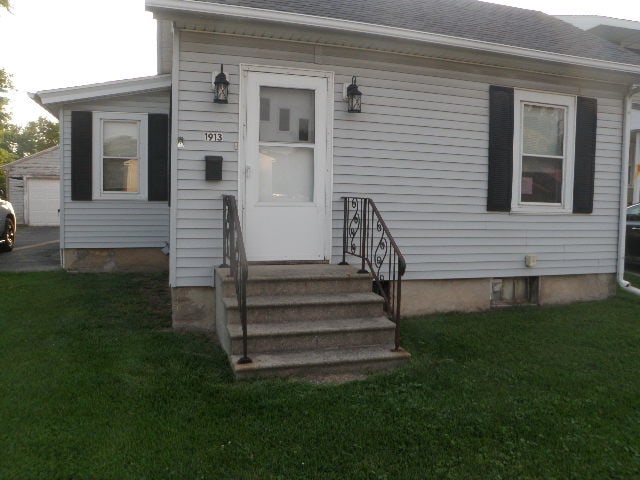 property entrance featuring a lawn