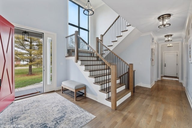 foyer featuring hardwood / wood-style flooring, crown molding, and a chandelier