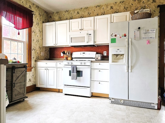 kitchen featuring white cabinets and white appliances