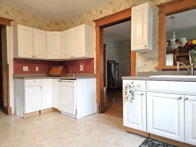 kitchen with white cabinetry, a chandelier, and white dishwasher