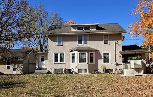 back of property featuring central AC unit and a lawn