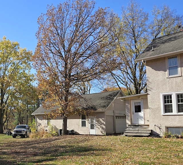 view of side of property featuring a garage and a lawn