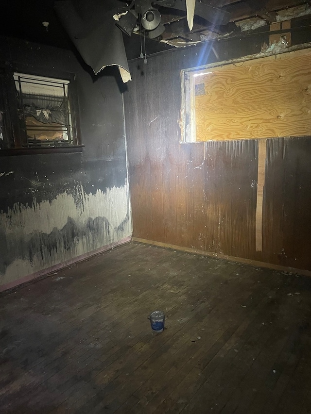 basement featuring hardwood / wood-style floors and wooden walls